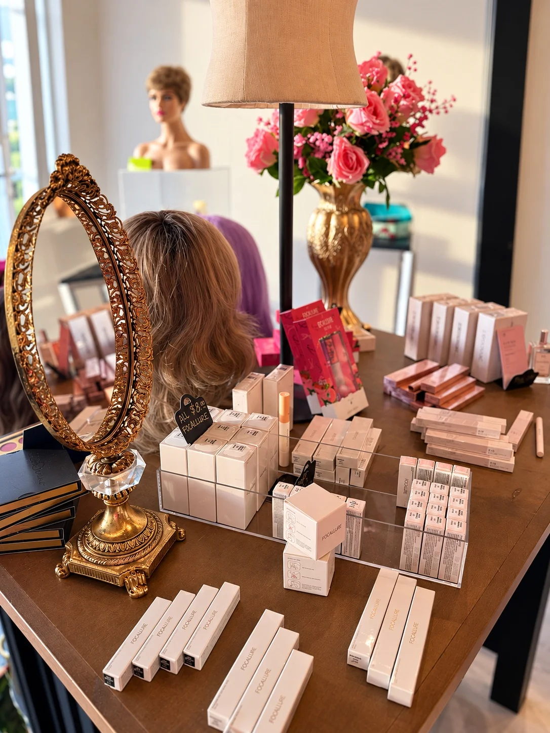 Makeup arranged beside an ornate gold mirror at Coiffed